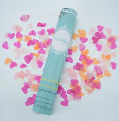 Confettis de papier de partie colorée tenue dans la main de coeur pendant le festival/nouvelle année
